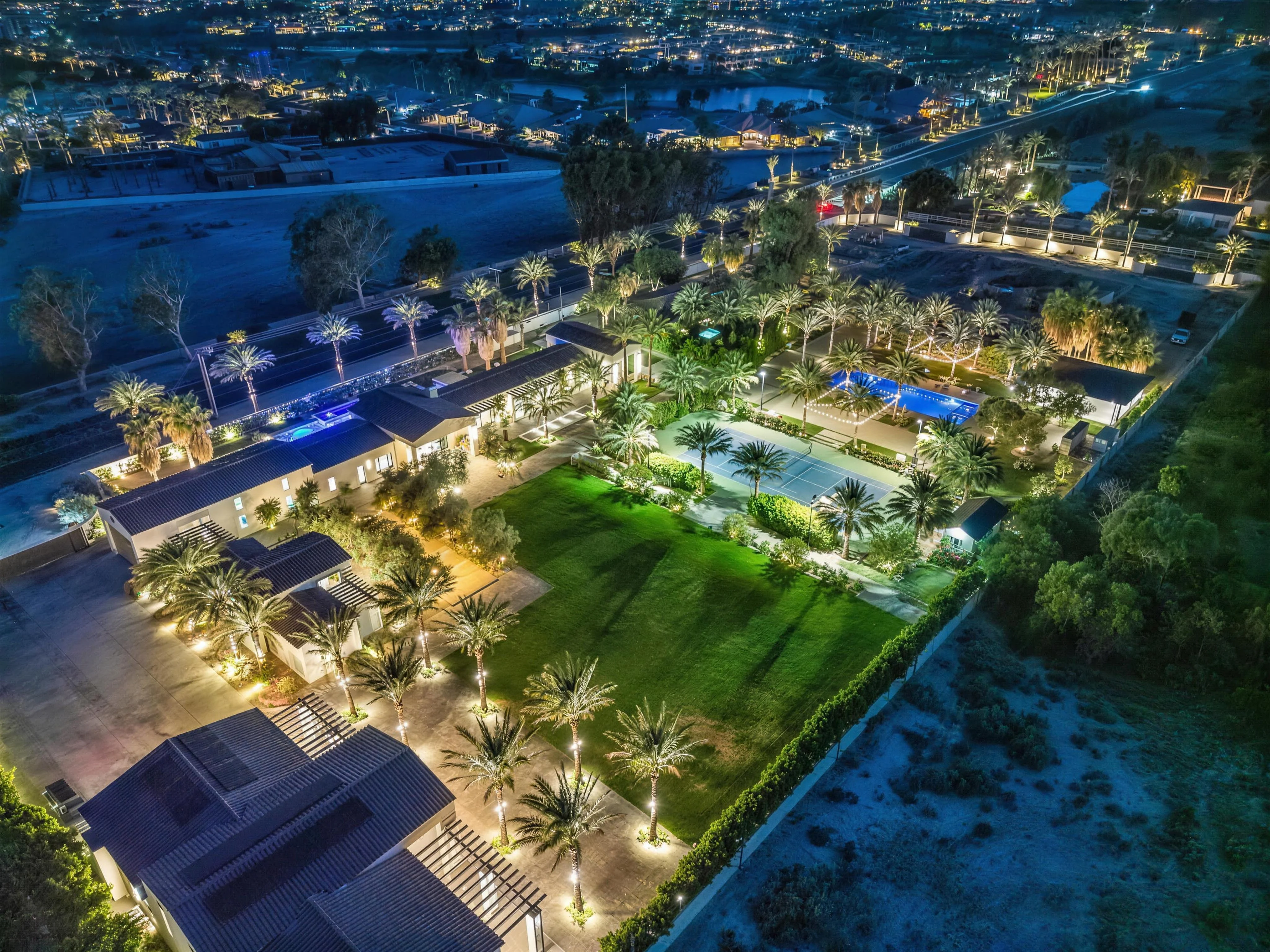 The estate lit at night against the Coachella Valley