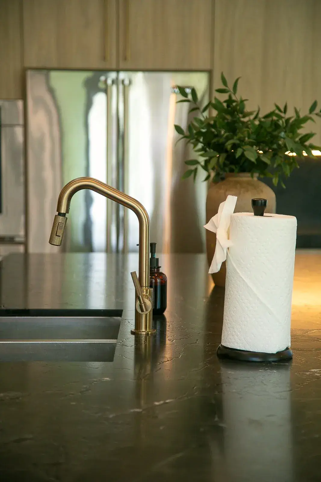 A kitchen detail in dark stone and brass