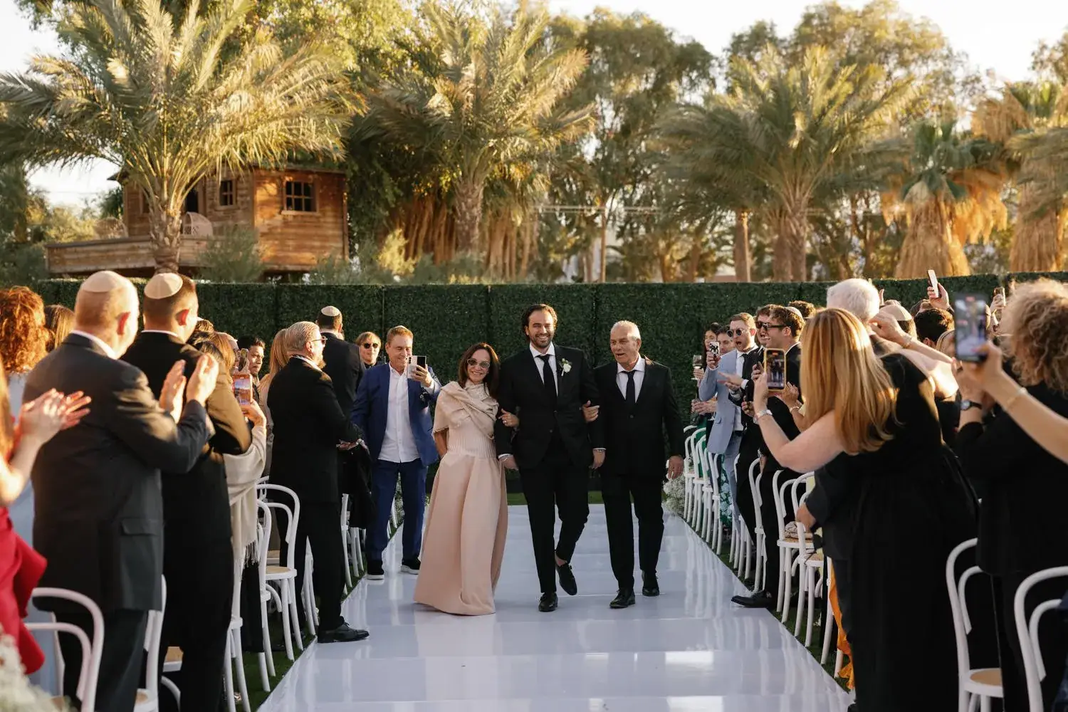 The processional down a white aisle lined with guests