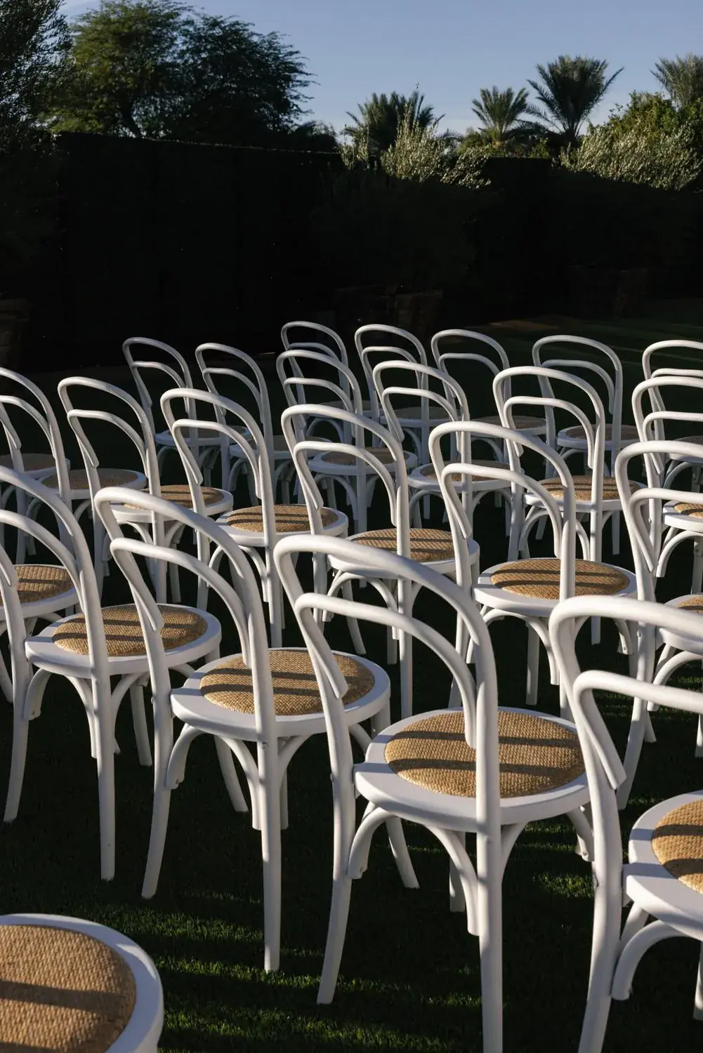 White ceremony chairs set on the lawn